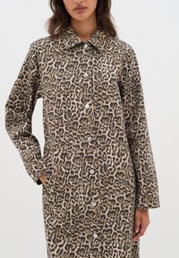 Lång leopardmönstrad kappa i texturerat tyg, med krage, långa ärmar och silverknappar framtill.
