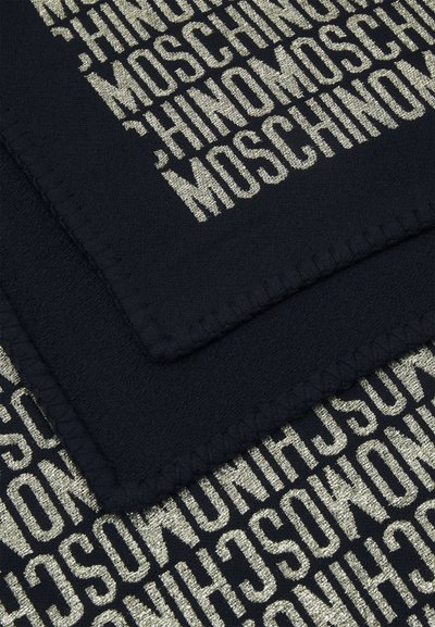 Mustaa kangasside, jossa on metallinhohtoinen kultainen brändäys, joka toistaa "Moschino"-tekstin rohkealla fontilla, tekstuuripinnalla ja ommelluilla reunoilla.