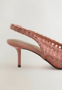 Roze geweven slingback hoge hak met een dunne naaldhak en gevlochten banddetails.
