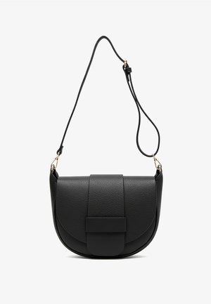 Czarnobiały top na ramiączkach w paski, niebieskie jeansy z wysokim stanem oraz czarna skórzana torba na ramię o zaokrąglonym kształcie i fakturowanym wykończeniu.