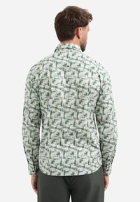 Heren langemouwen overhemd in lichte stof met een groen-wit abstract patroon, voorzien van een button-down kraag en een enkele knoop op de achterkant.
