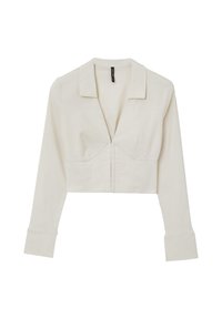 Chemise raccourcie à manches longues en tissu beige clair. Présente un col classique, un décolleté en V profond et une fermeture à boutons sur le devant. Texture lisse.