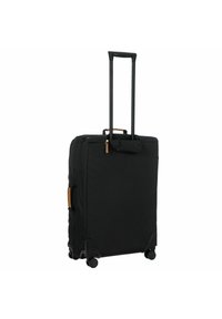 Schwarzer Rollkoffer mit rechteckiger Form, Außenmaterial aus Stoff, ausziehbarem Griff und vier Rädern für einfache Mobilität. Verfügt über goldene Reißverschlüsse und tanfarbene Akzente.