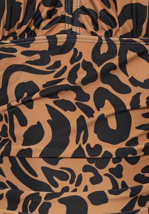 Kuvioitu leopardikangas ruskean ja mustan sävyissä, jossa on sileä pinta ja rypytetty yksityiskohta saumoissa.