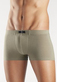Olivgrüne Boxershorts aus glattem Stoff mit einem kontrastierenden schwarzen Bund, der das Markenlogo zeigt. Enganliegende Form am Körper.