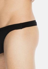 Schwarze Schwimmbrieft mit glatter Oberfläche und minimaler Abdeckung, ausgestattet mit einem dünnen Bund und genähten Nähten.