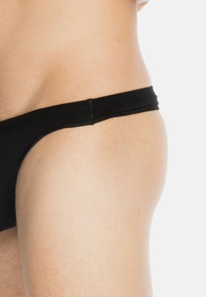 Black swim brief with a smooth texture and minimal coverage, featuring a thin waistband and stitched seams.