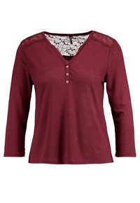 Burgundy långärmad topp med V-ringning, spetsdetaljer på axlarna, knapprad med tre knappar och en mjuk textur.