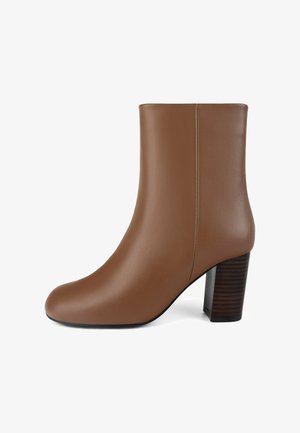 Braune Leder-Ankle-Boots mit glatter Textur, runder Zehenpartie und gestapeltem Blockabsatz. Das Design verfügt über ein nahtloses Obermaterial und dezente Nähte.