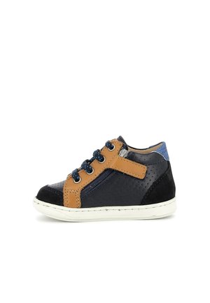 Baskets pour tout-petit bleu marine et beige avec côtés perforés, lacets bleus, fermeture éclair latérale et semelle blanche sur fond blanc.