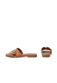 Tan læderslippers med en bred rem, der har en dekorativ spænde, flad sål og åben tå-design. Glat tekstur, minimalistisk stil.