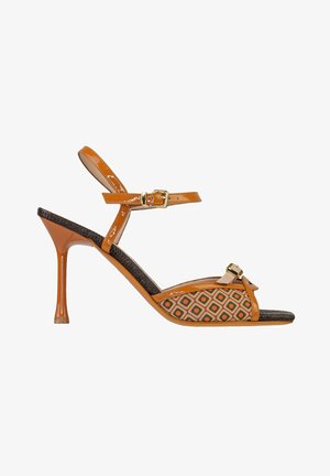 Sandalo con tacco alto color cuoio con cinturino alla caviglia, pannello laterale con motivo geometrico, punta aperta e piccolo dettaglio con fibbia sulla fascia frontale.