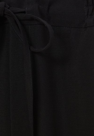 Tessuto nero con una trama testurizzata presenta una vita legata, enfatizzando una superficie liscia e un design generale scattante.