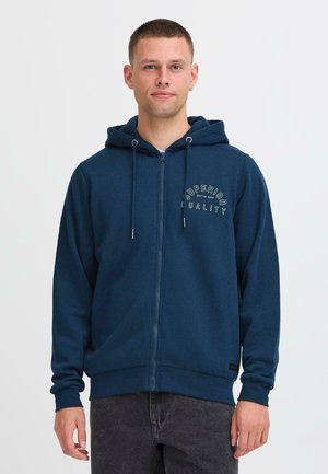 Marin zip-up hettegenser med snøring, med hvit tekstdesign "Superior Quality" på brystet og ribbestrikkede mansjetter og nederkant.