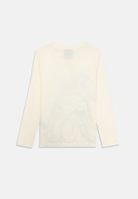 Cămășă din bumbac, cu mâneci lungi, de culoare crem, cu un design subtil cu caracatiță imprimer pe spate. Guler rotund și tiv drept.