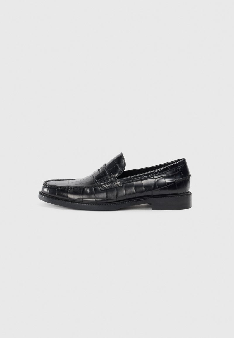 Mocasini negri din piele cu un model texturat de crocodil, un toc mic, și un design cu vârf rotund.