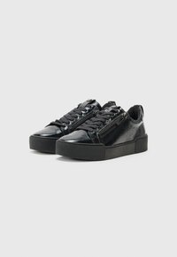Sneakers neri con finitura lucida in vernice, caratterizzati da punte arrotondate, suole in gomma nera testurizzata e chiusura con lacci nella parte anteriore con zip sui lati.
