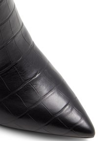 Botín de piel negra por el tobillo con punta afilada, que presenta un patrón de textura de cocodrilo y un acabado suave.