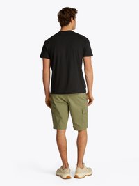 T-shirt noir à manches courtes, shorts cargo olive avec poches latérales, et chaussures de sport beiges, vus de l'arrière. Design simple et coupe décontractée.