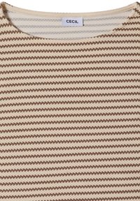 Gros plan d’un haut en tissu tricoté à rayures horizontales marron et beige avec un col rond et une étiquette blanche indiquant "CECIL" à l’arrière du col.