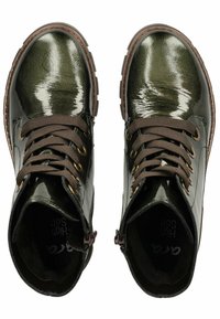Botas de tobillo brillantes de color verde oscuro con un acabado texturizado, cordones marrones, ojetes dorados y un acolchado en el tobillo. Cuentan con una suela de goma resistente.