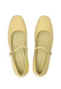 Gelbe Leder-Ballerinas mit abgerundeter Zehenpartie, versehen mit einem Riemen und einer silbernen Schnalle. Weiche, matte Textur und gepolsterter Innenraum.