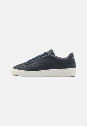 Navy nahka sneakerit valkoisella kumipohjalla, pyöreällä kärjellä, sävy sävyyn ommeltuna ja sinisillä kengännauhoilla. Sisältää teksturoitu tausta ja brändin logo.
