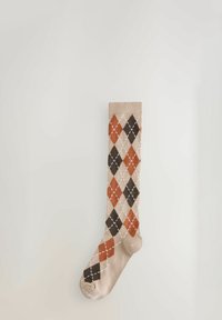 Beige Kniestrümpfe mit einem Argyle-Muster in Orange, Braun und Creme sowie weißen Diamantakzenten. Weicher Stoff, gerippter Bund.