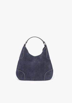Granatowa zamszowa torebka na ramię z zakrzywionym górnym uchwytem, białymi przeszyciami i zaokrąglonym, lekko trapezowym kształtem.