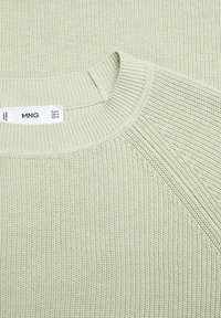 Hellgrüner Strickpullover mit einem gerippten Rundhalsausschnitt und strukturiertem Design. Verfügt über Raglanärmel und ein Etikett mit Größen- und Markhinweis.