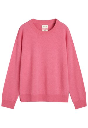 Rosa tröja med rundad halsringning, långa ärmar, ribbat nederkant och något lös passform. Tillverkad av mjukt tyg, med sidoklipp i nederkant.