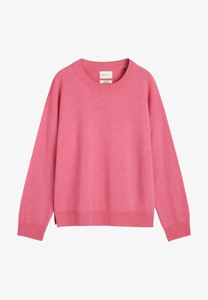 Rosa tröja med rundad halsringning, långa ärmar, ribbat nederkant och något lös passform. Tillverkad av mjukt tyg, med sidoklipp i nederkant.