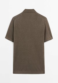 Pánská polo košile s krátkým rukávem v jedné barvě, v zemitě hnědé barvě. Má žebrovaný límeček a manžety, se hladkým, mírně texturovaným materiálem.