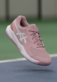 Hellrosa Sportschuhe aus Mesh- und Synthetikmaterial, mit weißen Akzenten, einer strukturierten Sohle und einem gepolsterten Design für Unterstützung.