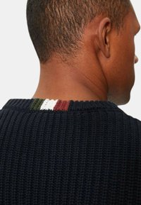 Maglione lavorato a maglia in navy con una texture a costine, caratterizzato da un accento a righe multicolori sullo scollo posteriore in verde, bianco e rosso.
