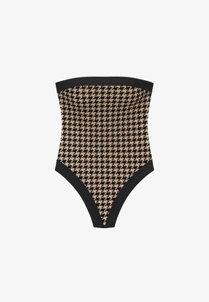 Højtaljet bandeau badedragt i houndstooth mønster, med beige og sorte farver, samt en ensfarvet sort kant øverst og ved benåbningerne.