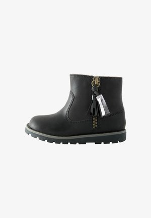 Stivaletto nero alla caviglia con cerniera laterale e nappine decorative, suola spessa e finitura in pelle liscia.