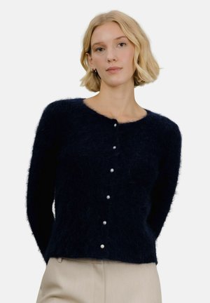 Mørkeblå mohair cardigan med en myk tekstur, rund halslinning og fem perleknapper foran. Figurtilpasset design, lange ermer.