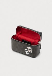 Taisnstūra kosmētikas soma brūnā rakstainā materiālā ar melniem akcentiem. Sarkans iekšējais oderējums, rāvējslēdzēja aizdare un priekšpusē karikatūru tēlu dizains.