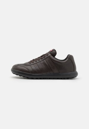 Brown leather sneaker featuring a rounded toe, lace-up design, subtle stitching details, and textured rubber sole for grip.