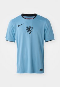 Maglia Nike azzurra con accenti neri, dotata di un emblematico leone sul petto e colletto nero. Realizzata in tessuto liscio e traspirante.