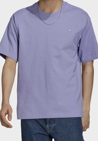 Fialové bavlněné tričko s kulatým výstřihem a krátkými rukávy, které má na hrudi malé vyšívané logo a volný střih.