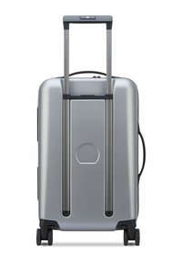 Silver hard-shell suitcase with a telescoping handle, dual wheels, and a molded design, featuring a distinctive circular accent.