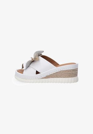 Weiße Plateausandalen mit einem glatten Lederoberteil, offener Zehe und einem dekorativen grauen Blumenakzent am Riemen. Gewebtes Jute-Design auf dem Keil.