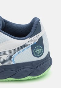 Sportiniai bateliai su kvėpuojančiu šviesiai mėlynu tinklu, tamsiai mėlynomis detalėmis, juodu tekstūruotu padu ir žalia kulno dalimi, suteikiančia papildomą atramą.
