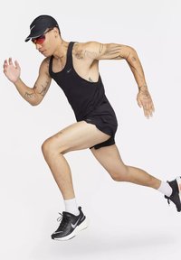Schwarzes ärmelloses Sport-Top, schwarze Shorts und schwarze Laufschuhe mit weißer Sohle; Läufer trägt eine Kappe und getönte Sonnenbrillen.
