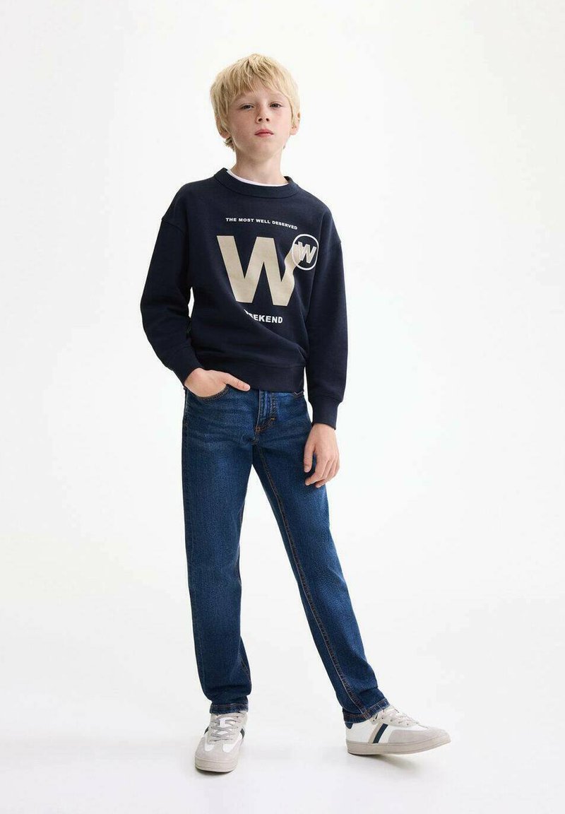 Felpa navy con testo bianco e oro, inclusi 'W' e 'WEEKEND', abbinata a jeans blu e sneakers grigie con dettagli a righe.