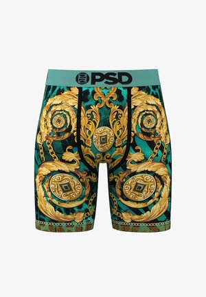 Bermudas con una cinturilla turquesa, intrincados patrones barrocos dorados y un diseño acentuado en negro con cadenas y medallones.