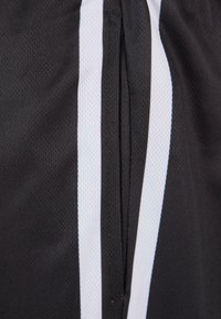 Svarta sportshorts med vita sidostreck, gjorda av ett texturerat, andningsbart tyg. Har en elastisk midja med dragsnöre.