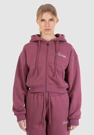 Hoodie bourgogne court en matériau doux avec une fermeture éclair, un capuche à cordon de serrage et des poches avant, arborant un logo brodé.